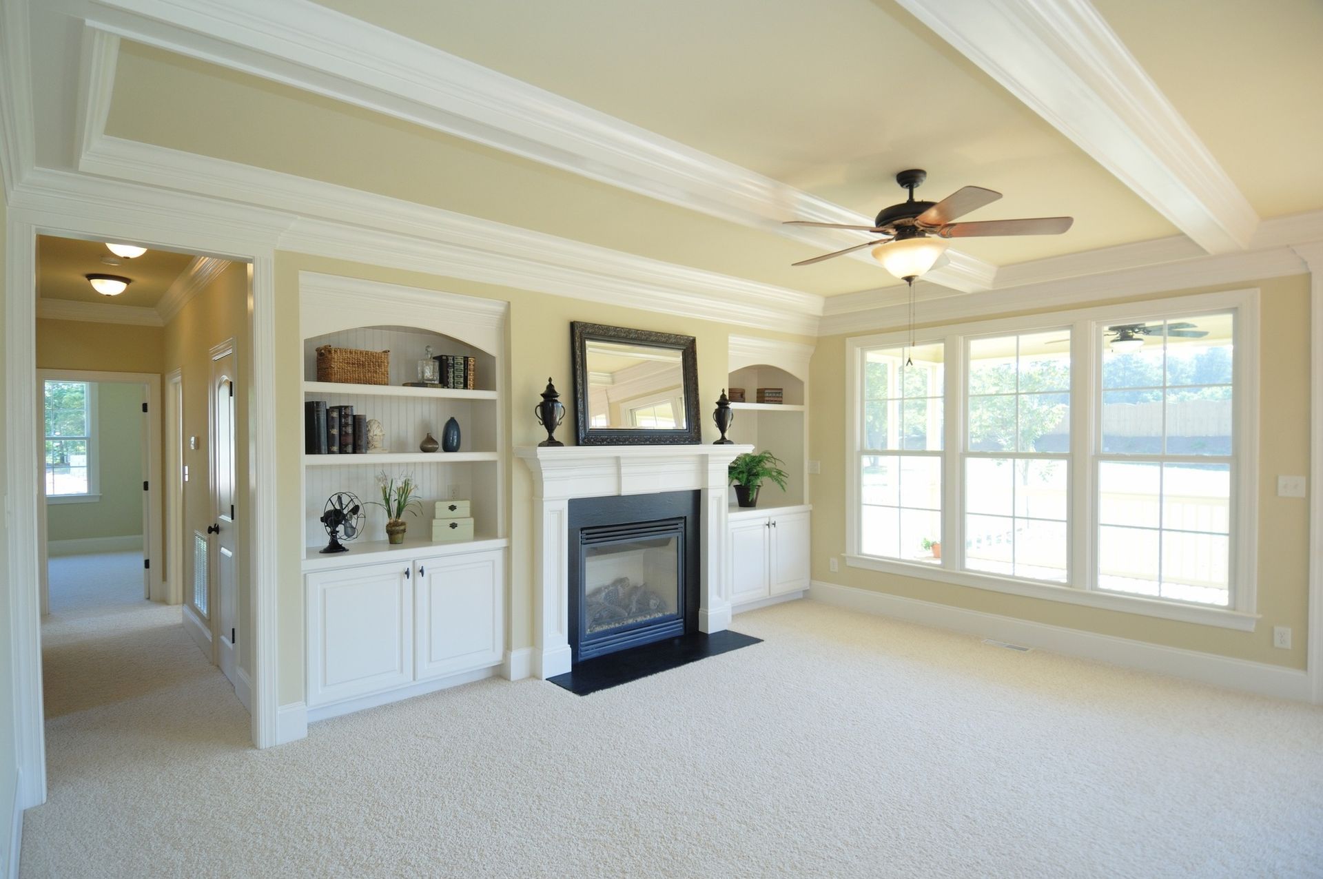 A living room with a fireplace and a ceiling fan