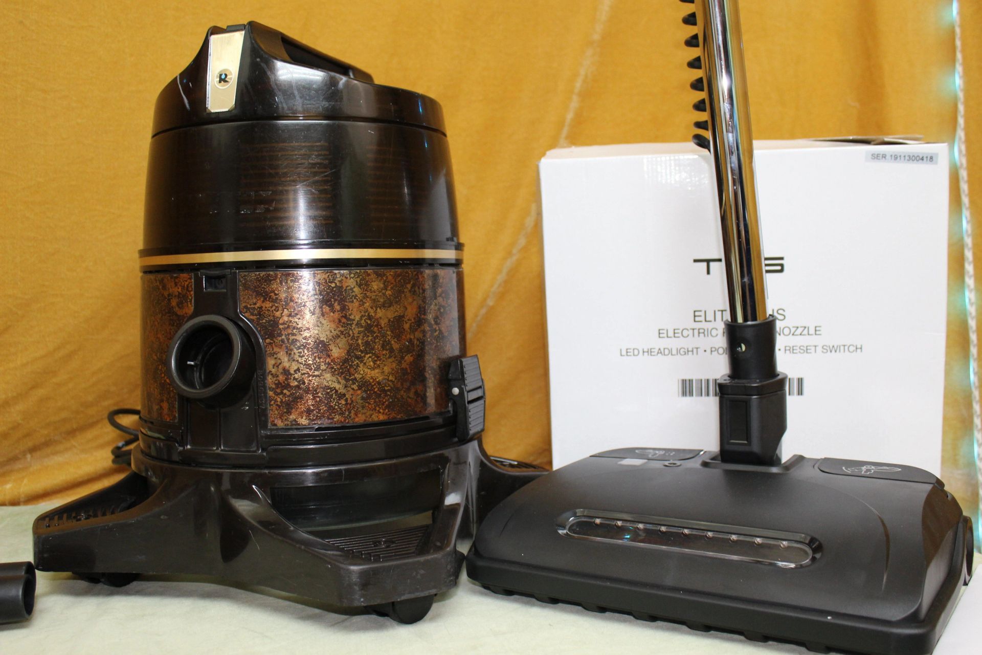 Two vacuum cleaners are sitting next to each other on a table