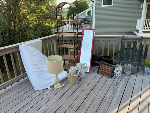 Items on a wooden deck: shelves, mirror, lamp, basket, and other decor.