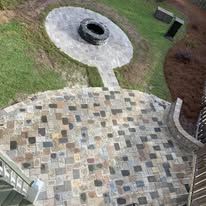 An aerial view of a patio with a fire pit in the middle.