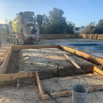 A concrete mixer truck is pouring concrete into a pool.