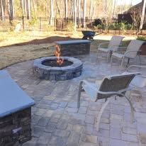 There is a fire pit in the middle of the patio.