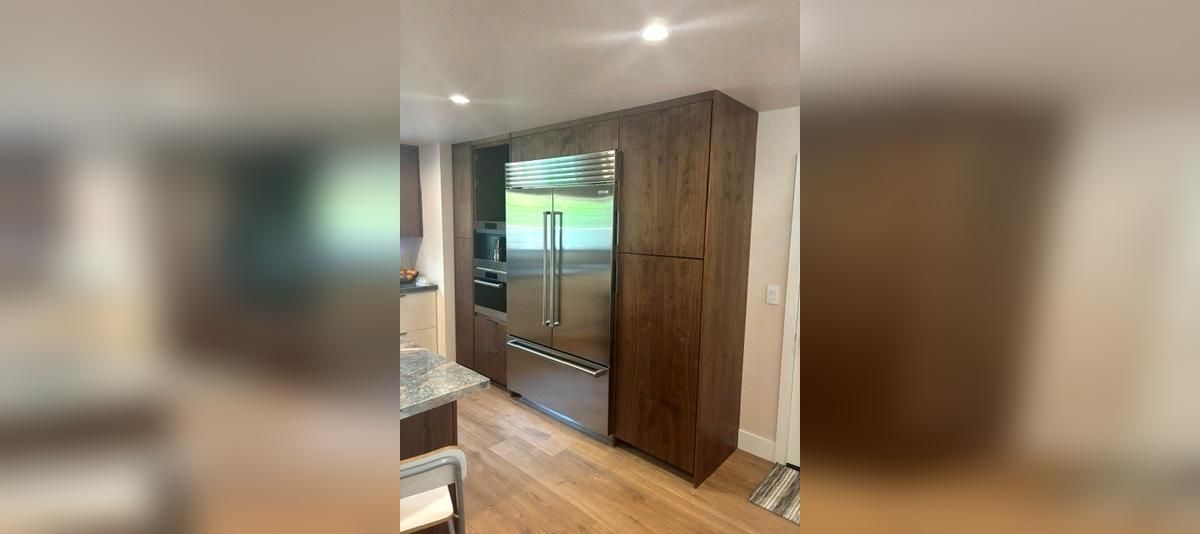 Modern bedroom with wooden wardrobe, mirrored doors, and a TV on a wall-mounted shelf