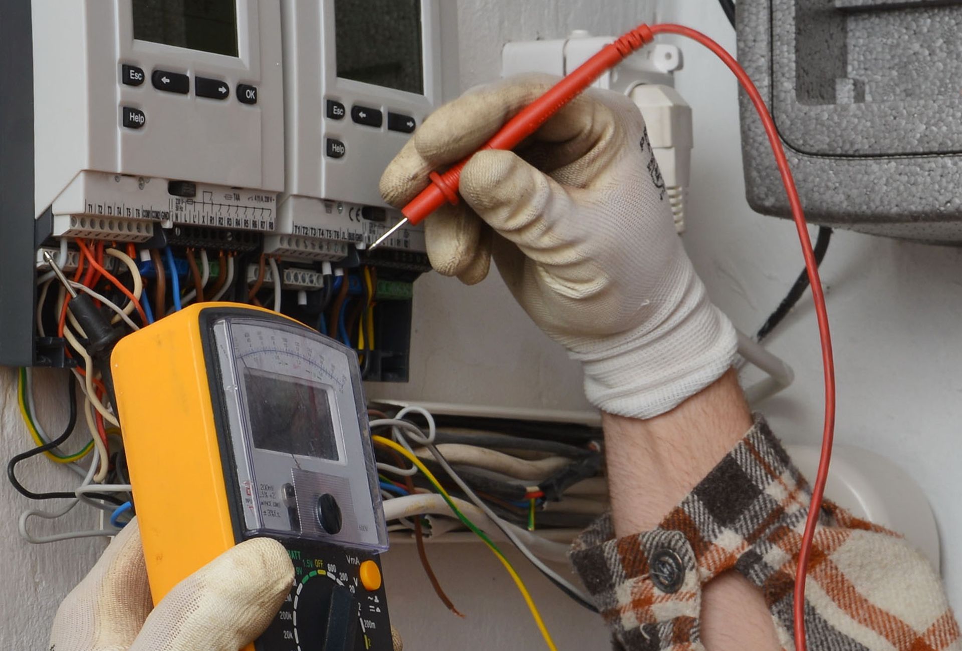 an electrician is using a multimeter to test a circuit board