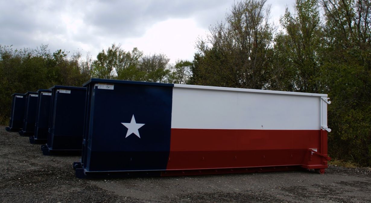 Dumpster painted with the Texas flag, parked outdoors.