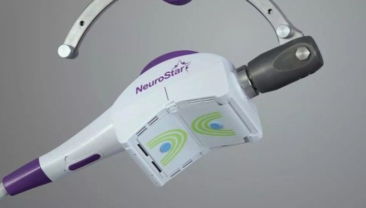 Close-up of a purple-and-white NeuroStar medical device against a gray background