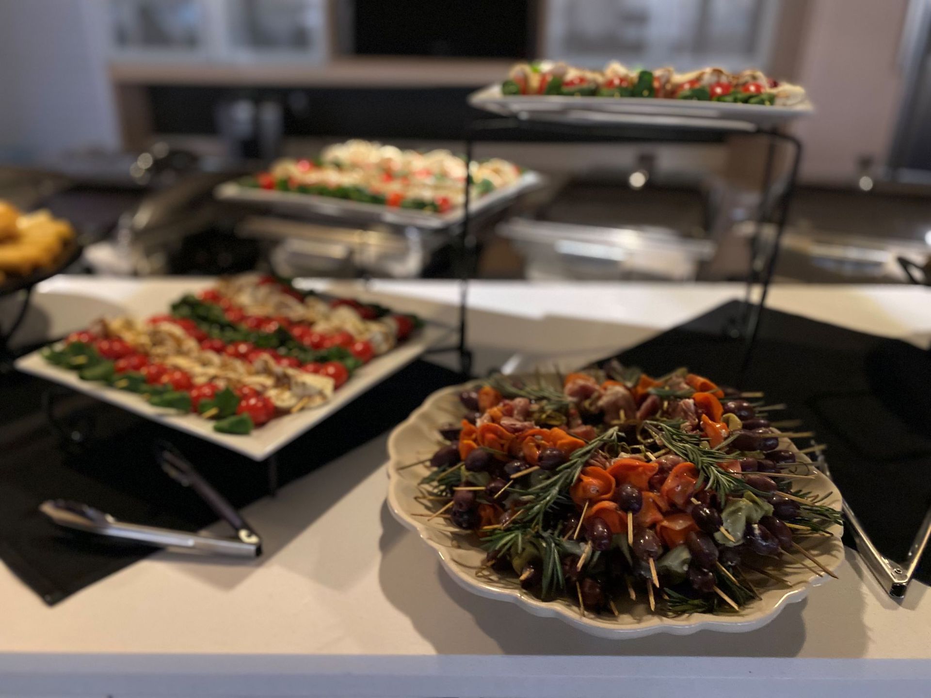 Buffet with various appetizers on white and black platters.