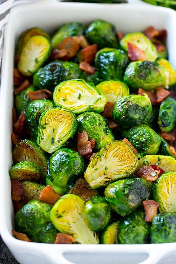 Roasted Brussels sprouts with bacon in a white dish.