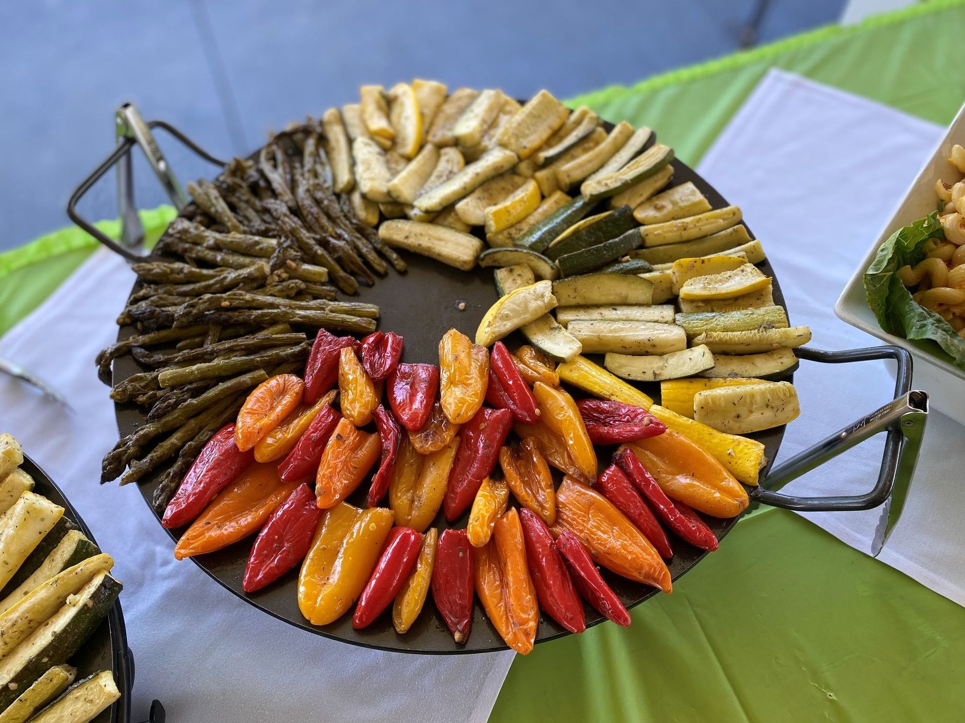 Roasted vegetables arranged on a large platter: asparagus, bell peppers, zucchini, and yellow squash.
