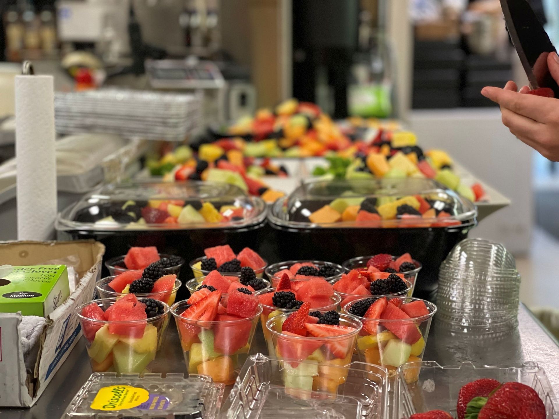 Fruit salad in plastic containers, cups, and trays.