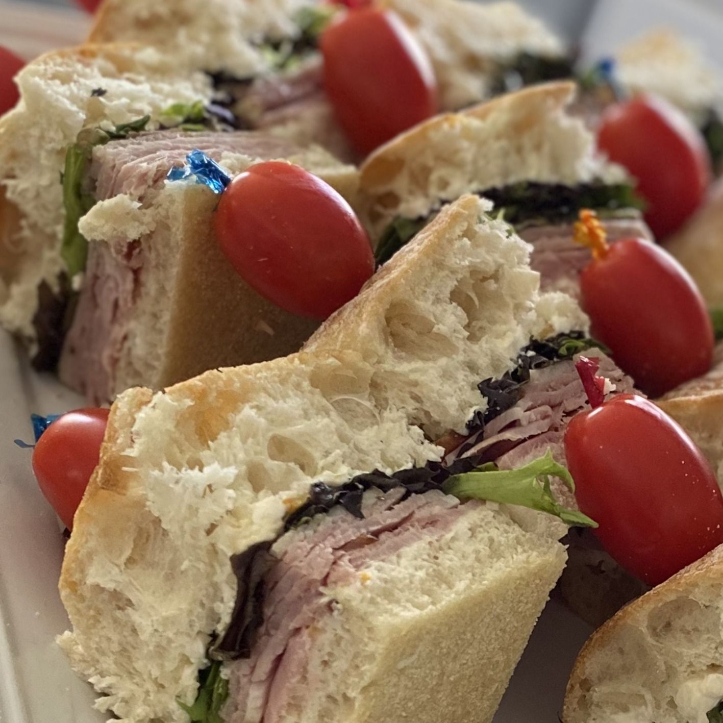 Sandwiches and cherry tomatoes on a platter.