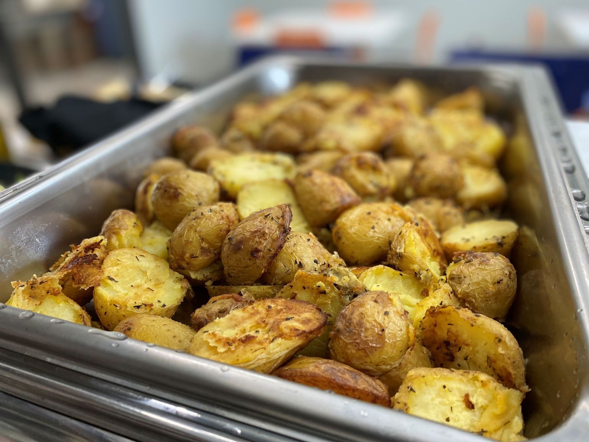 Roasted potatoes in a metal serving dish.
