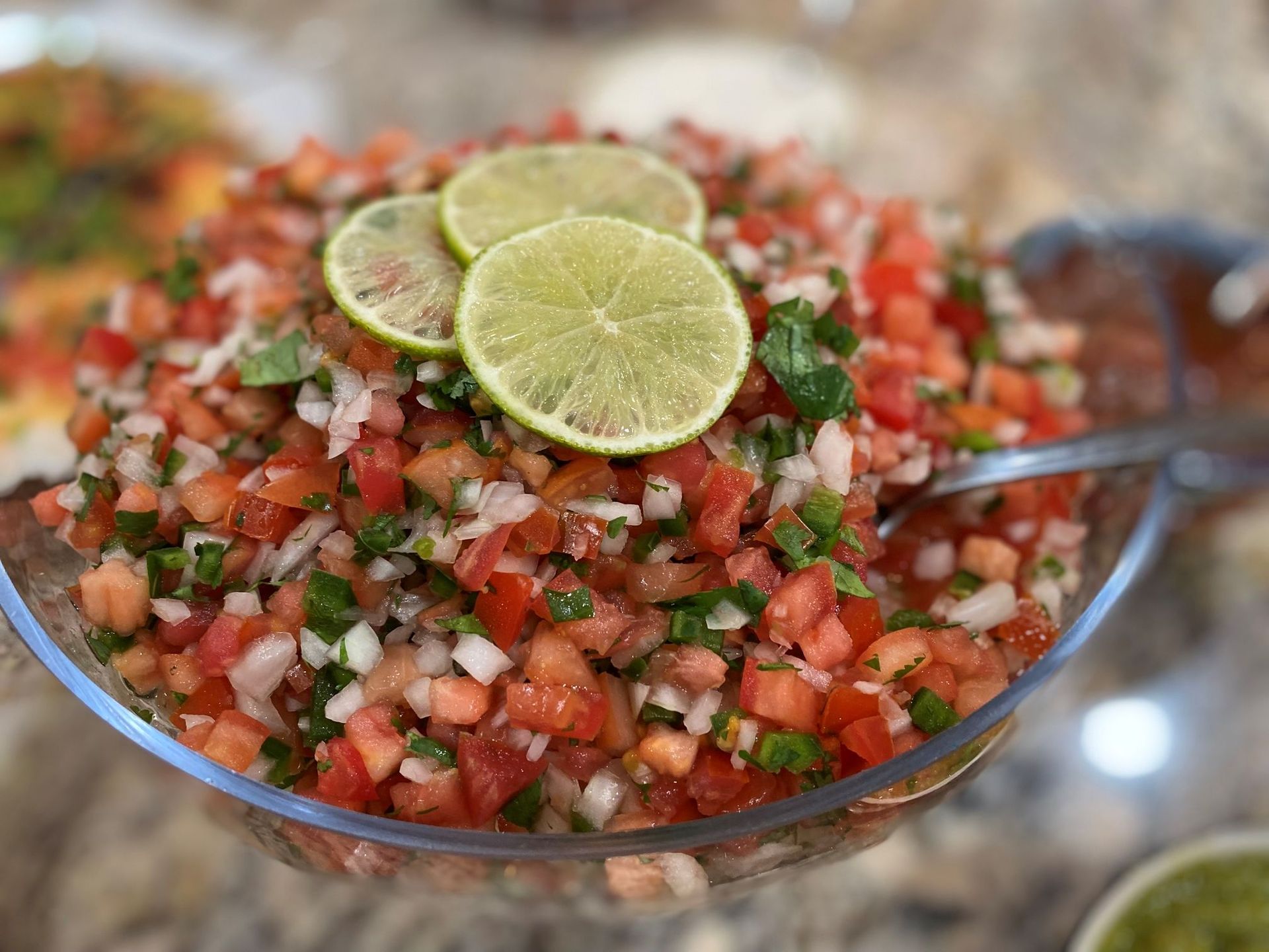 Bowl of fresh pico de gallo with lime slices on top.