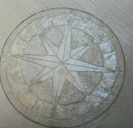 Compass rose design etched into pavement.
