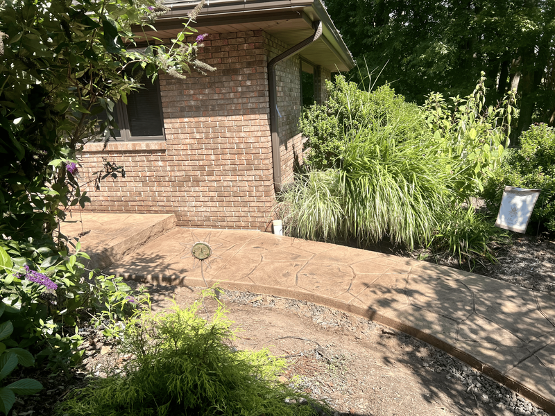 Brick building with stamped concrete walkway and landscaping.