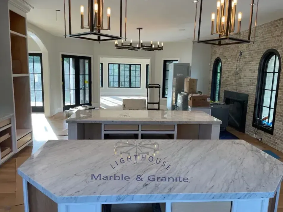 Newly constructed kitchen with marble countertops, chandeliers, and arched windows.