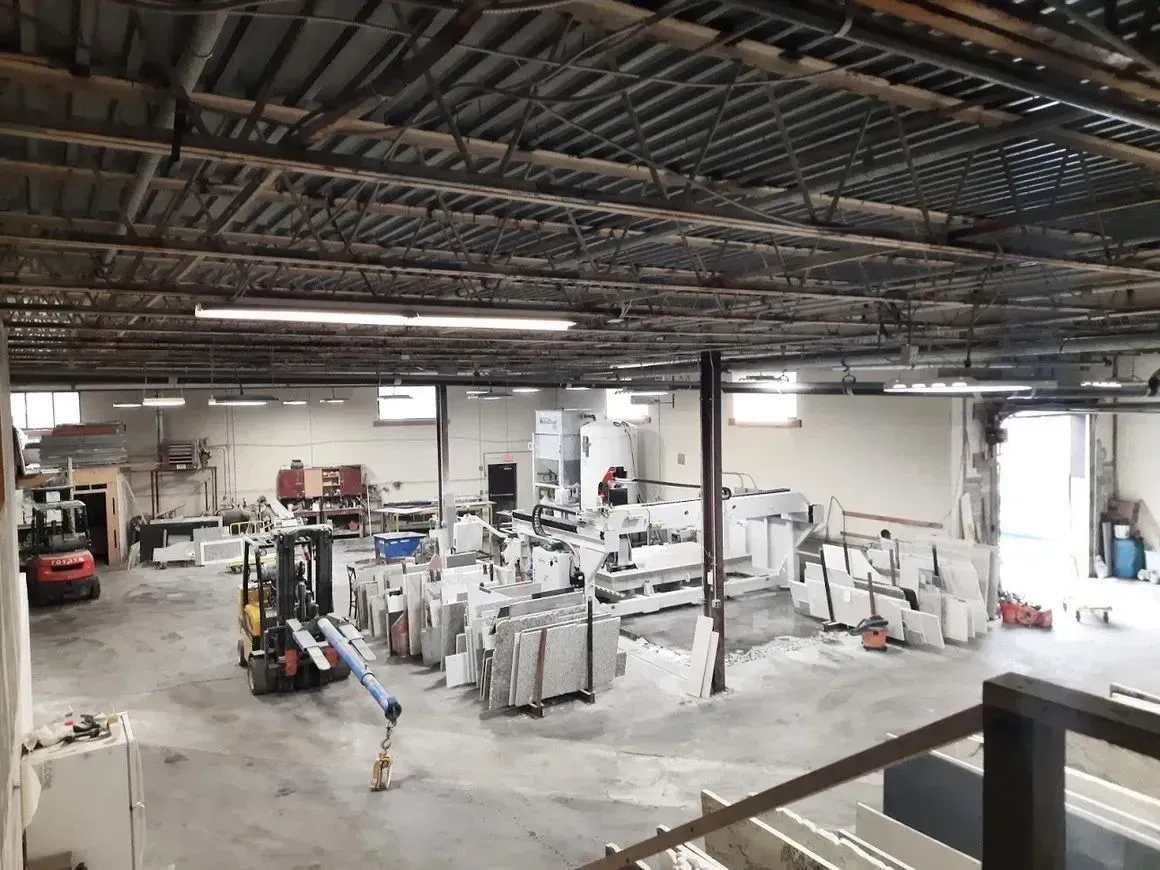 Industrial interior with machinery, a forklift, and building materials.