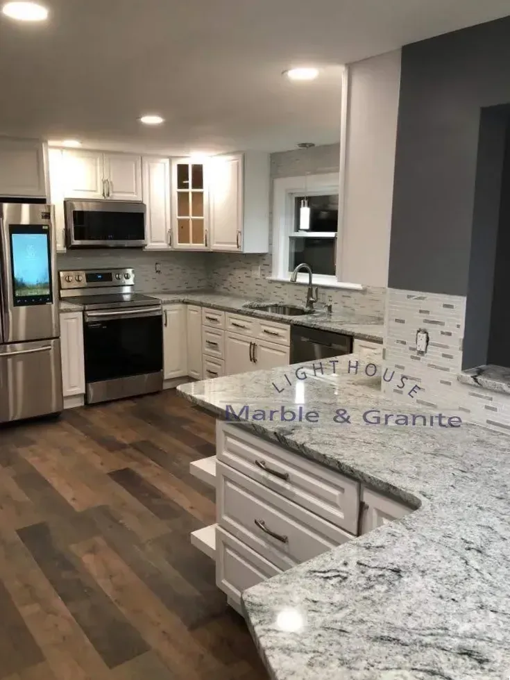 Kitchen with white cabinets, granite countertops, stainless steel appliances, and wood floors.
