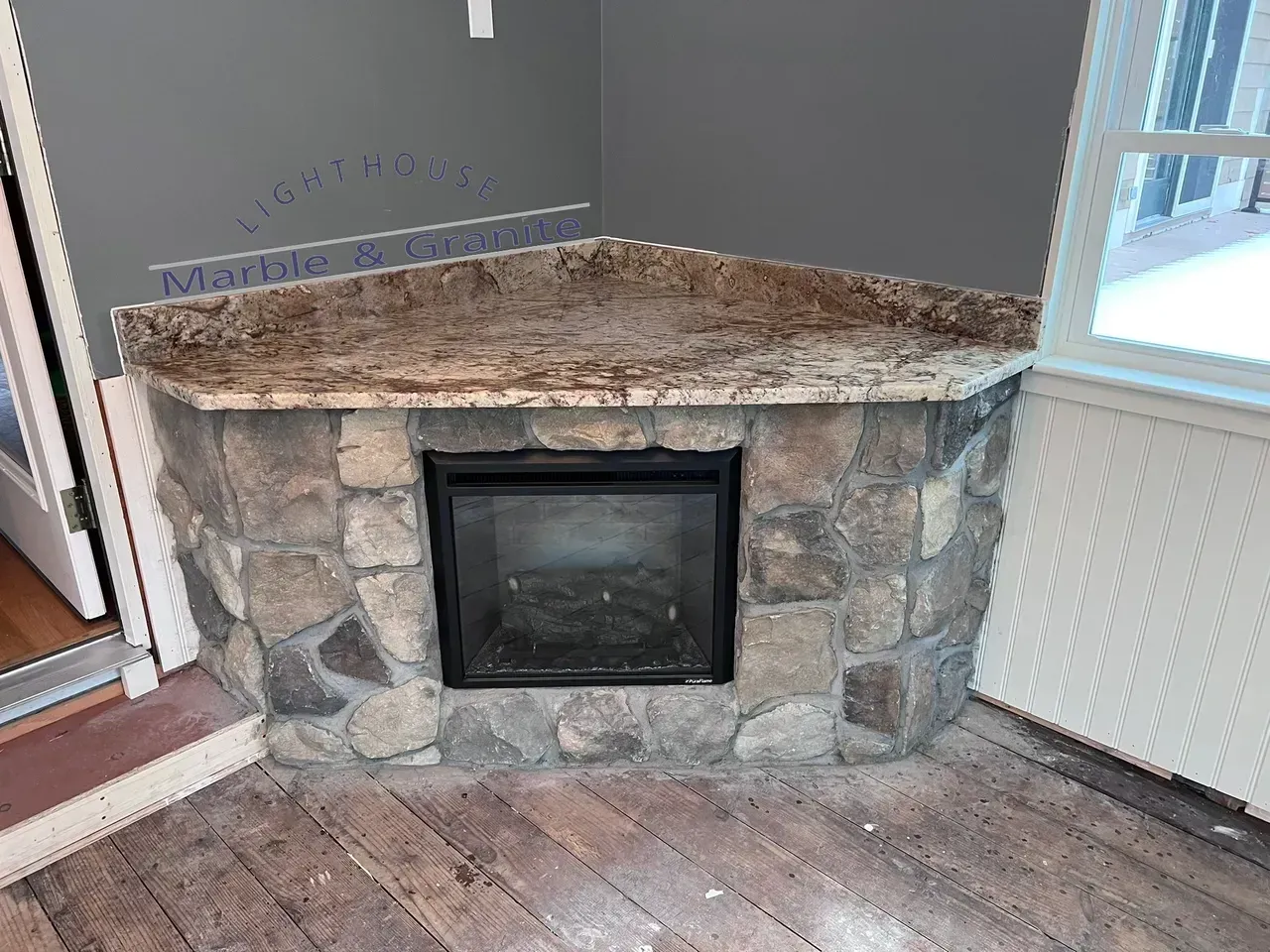 Corner fireplace with stone facade and granite top.