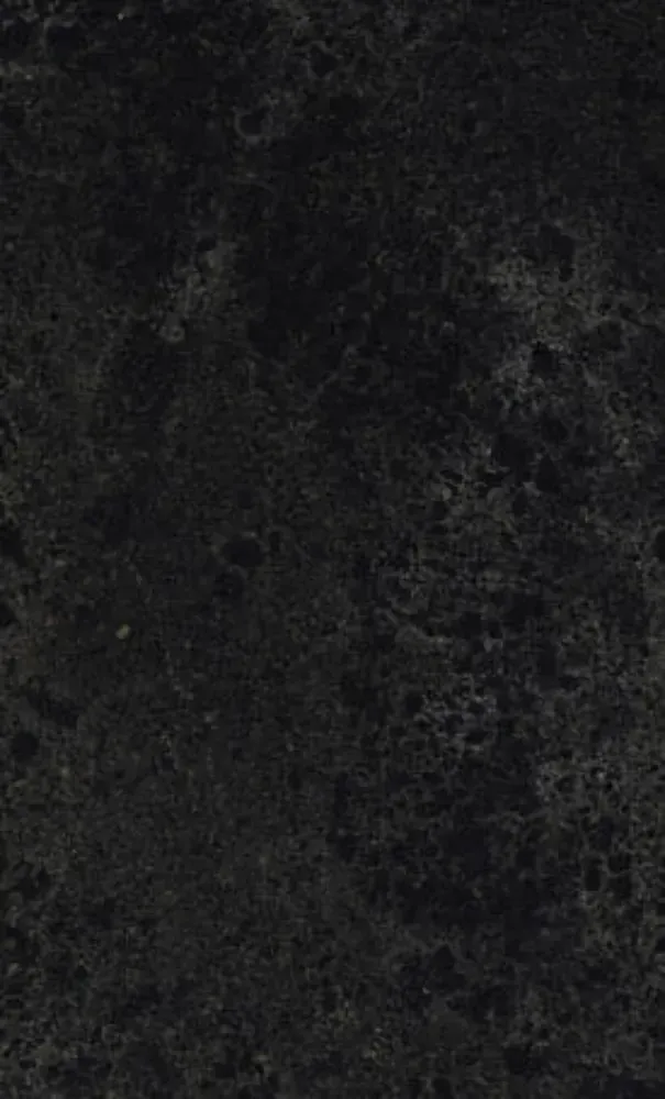 Dark textured surface, possibly stone or granite, with a mottled, uneven appearance.