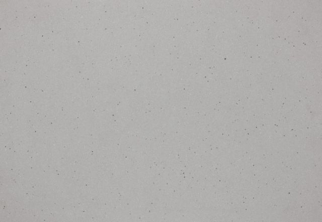 Light gray wall with small dark speckles.