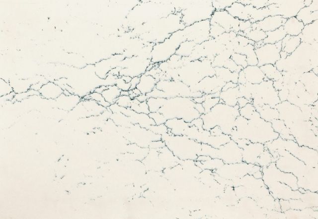 Cream-colored surface with thin, dark blue vein-like patterns resembling cracks.