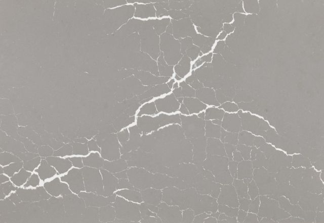 Gray surface with prominent white vein-like cracks.