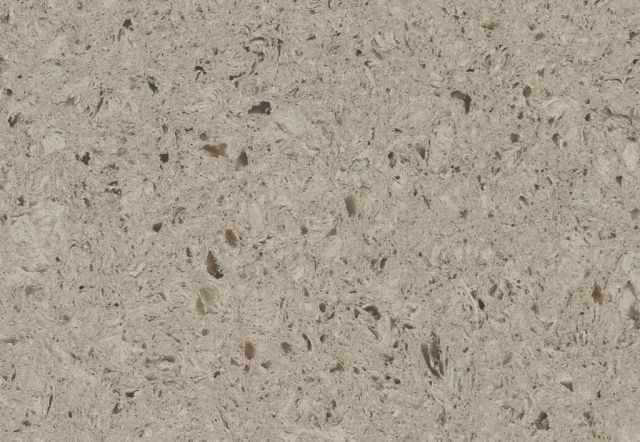 Close-up of a beige quartz countertop with a speckled pattern and some dark brown inclusions.