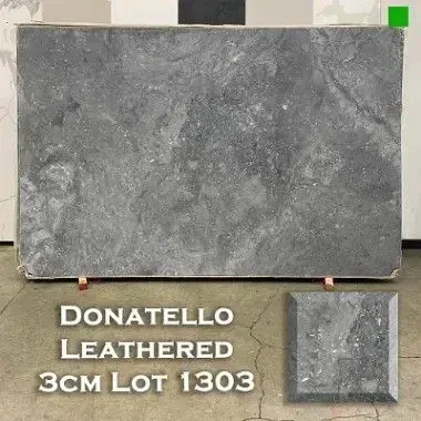 Large rectangular slab of Donatello Leathered stone, gray with variations. A small, square sample is below.