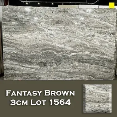 Fantasy Brown granite slab with wave-like patterns in shades of gray, white, and brown.