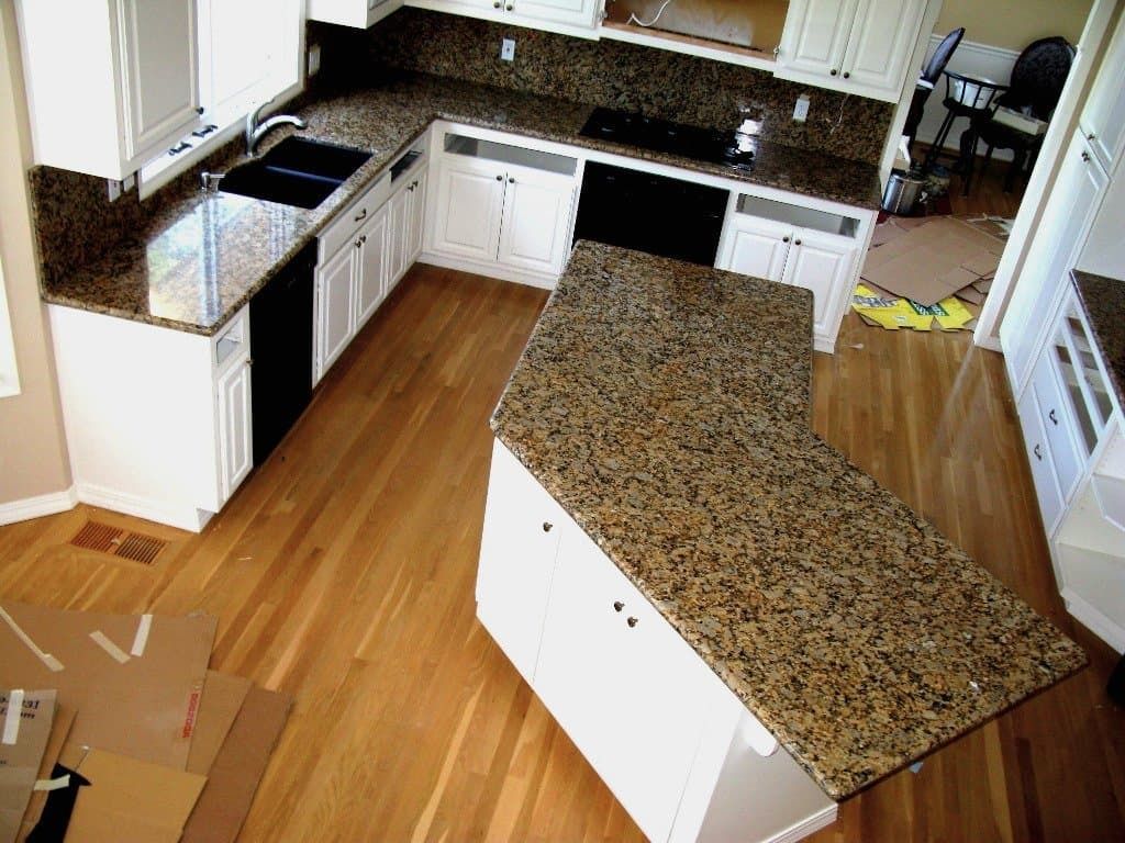 Kitchen with white cabinets, granite countertops, and wood flooring.