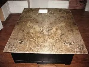 Kitchen island with a speckled brown countertop and black base.