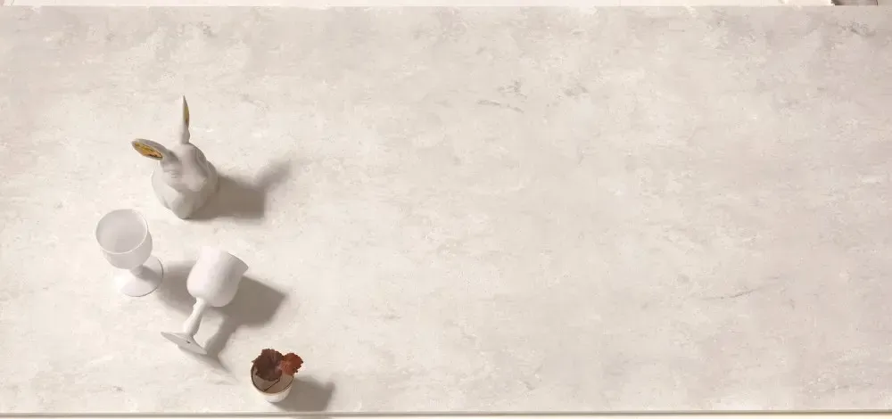 White surface with a white bird, glasses and brown objects.