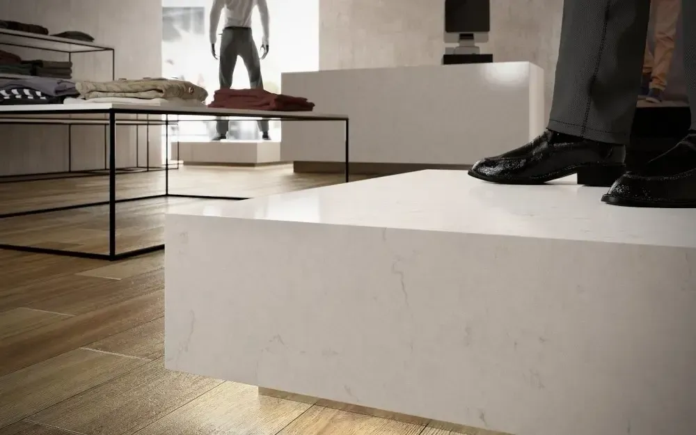 Mannequins in a modern retail store with white displays and wooden floors.