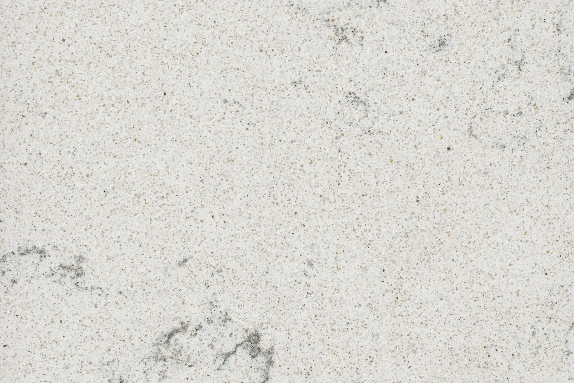 Close-up of a white quartz countertop with speckled gray and black flecks.