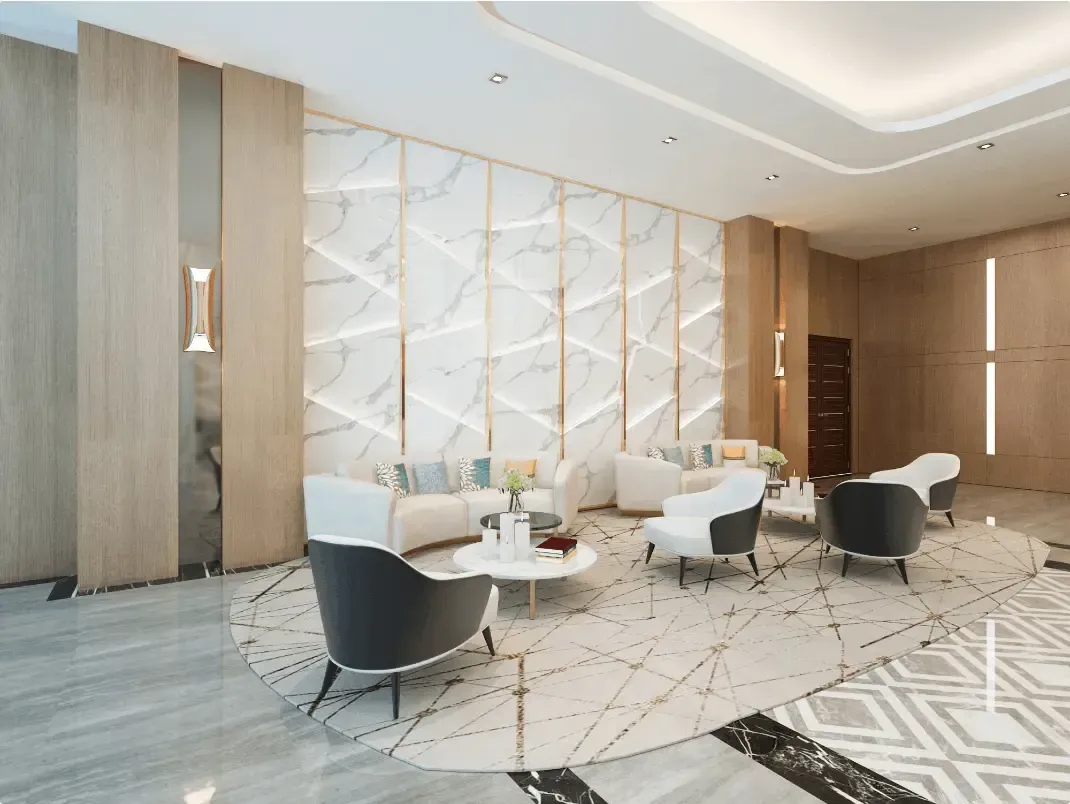 Lounge area with marble wall, light wood accents, white and dark armchairs, and a patterned rug.