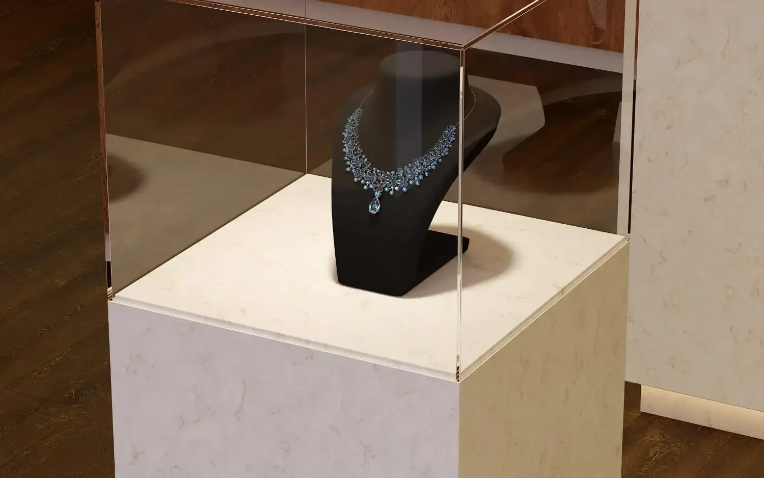 A jeweled necklace displayed inside a glass case on a white pedestal.