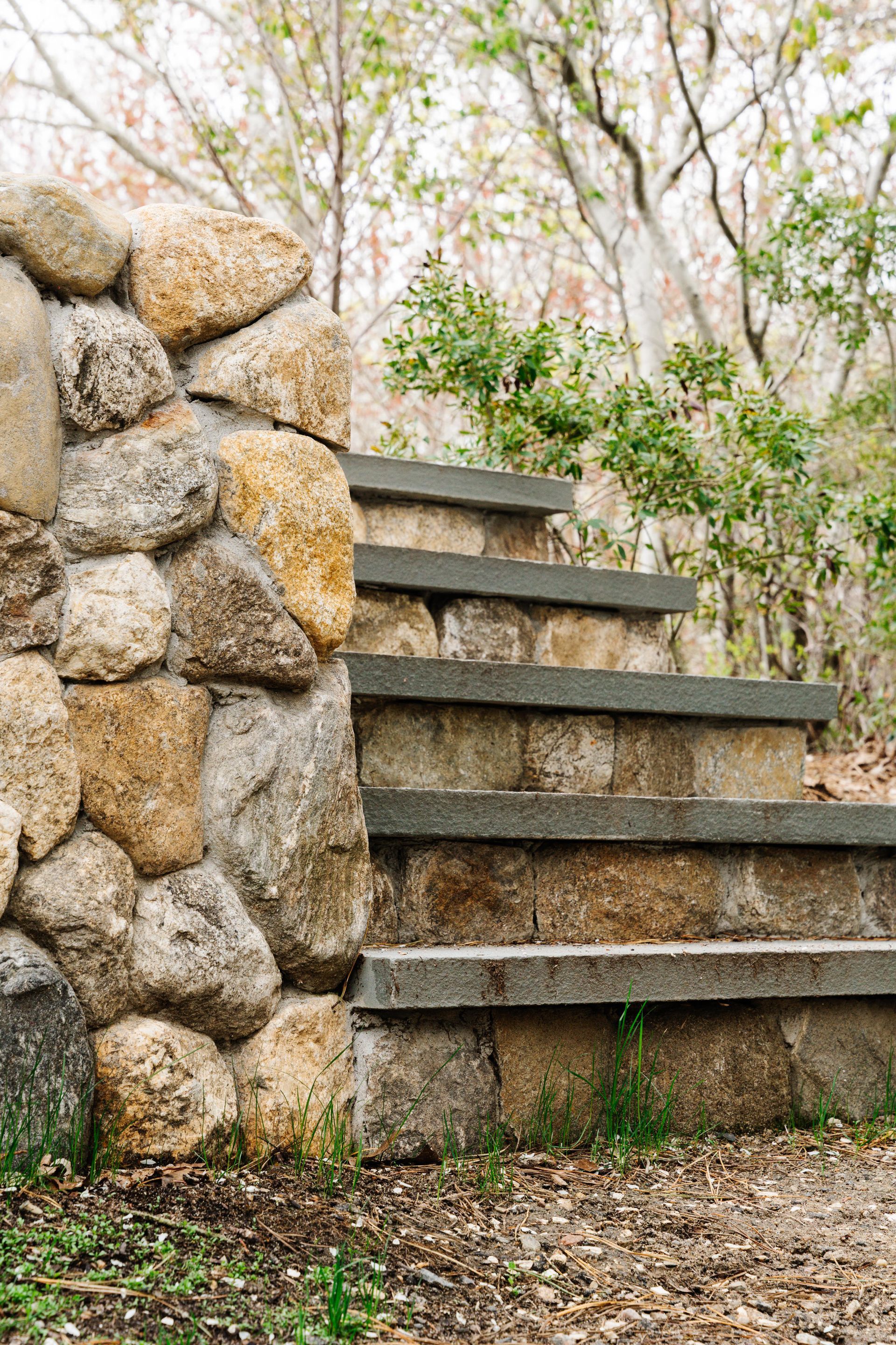 A set of stone stairs leading up to a stone wall.