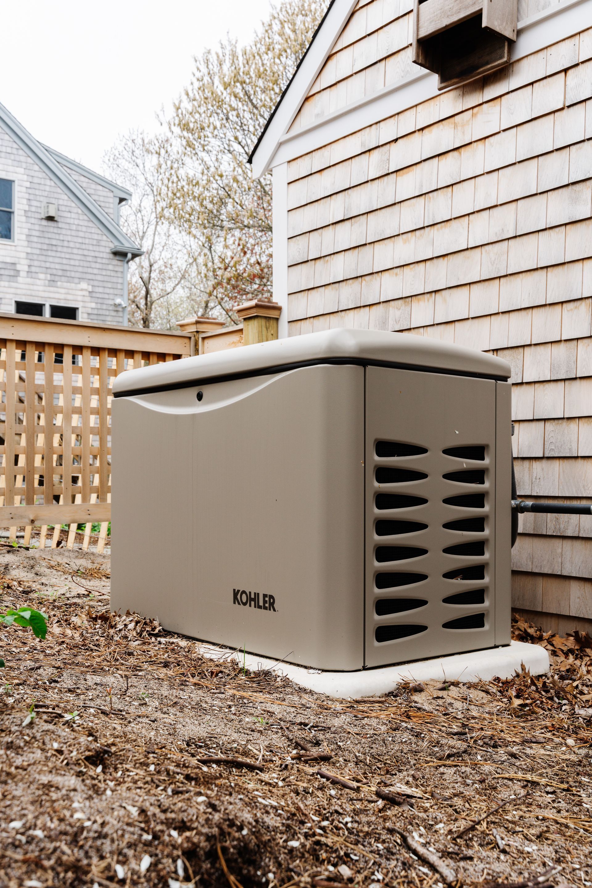 A generator is sitting on the side of a house.