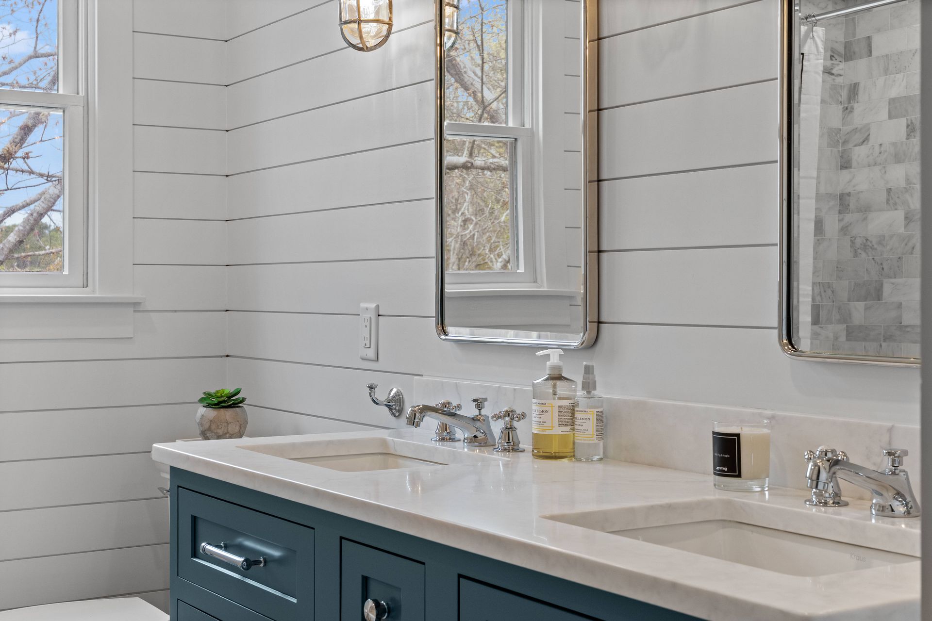 Bathroom with two sinks, a toilet, and a mirror.