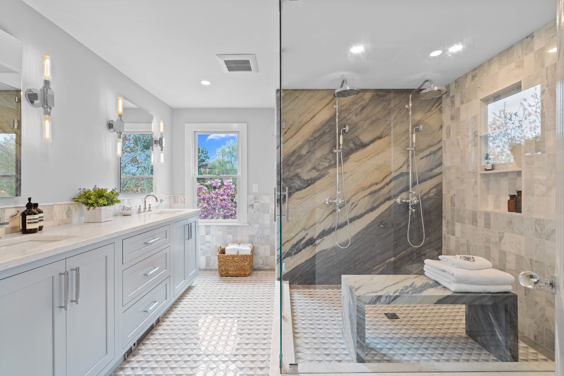 A bathroom with a walk in shower and two sinks.