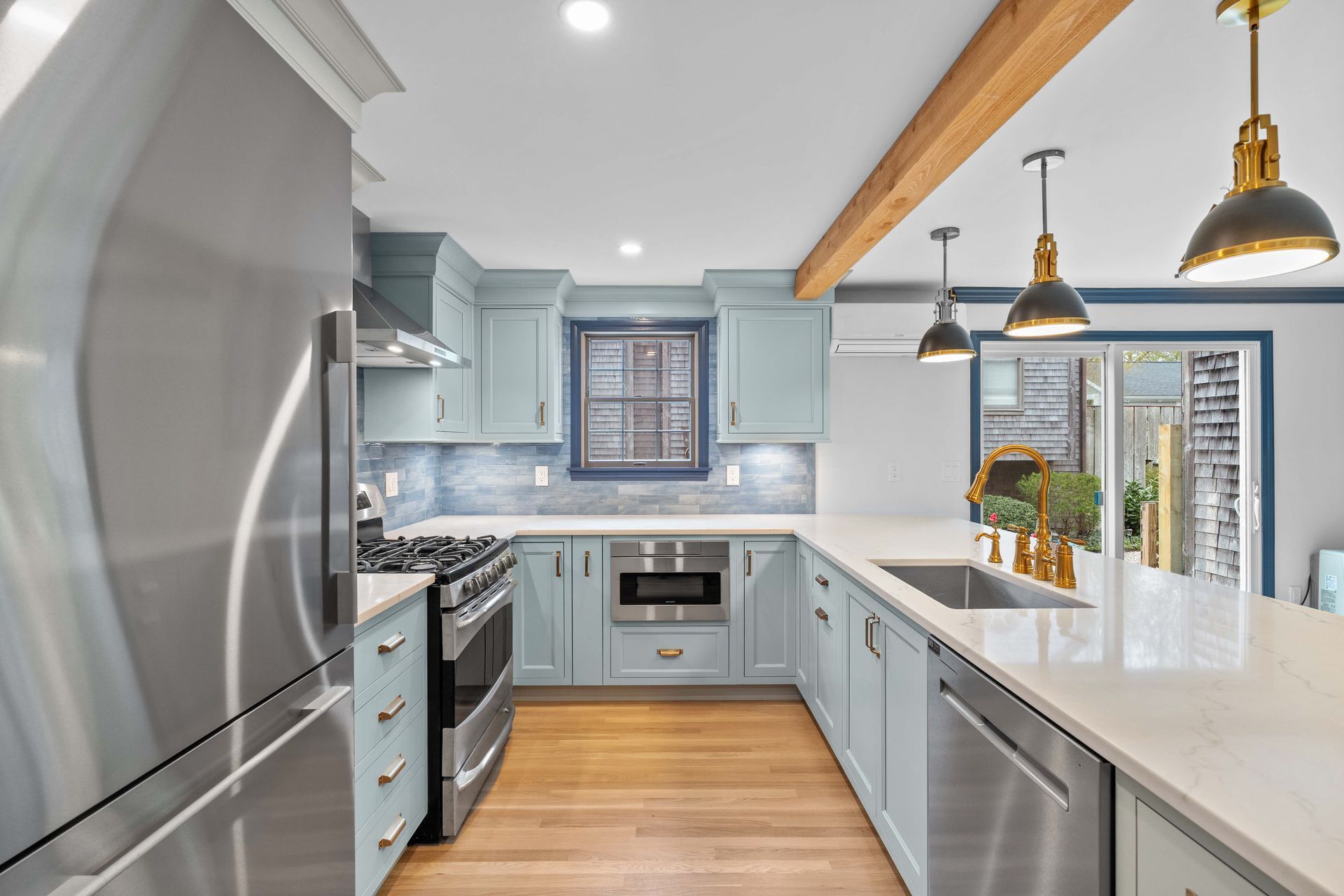 A kitchen with stainless steel appliances and blue cabinets.