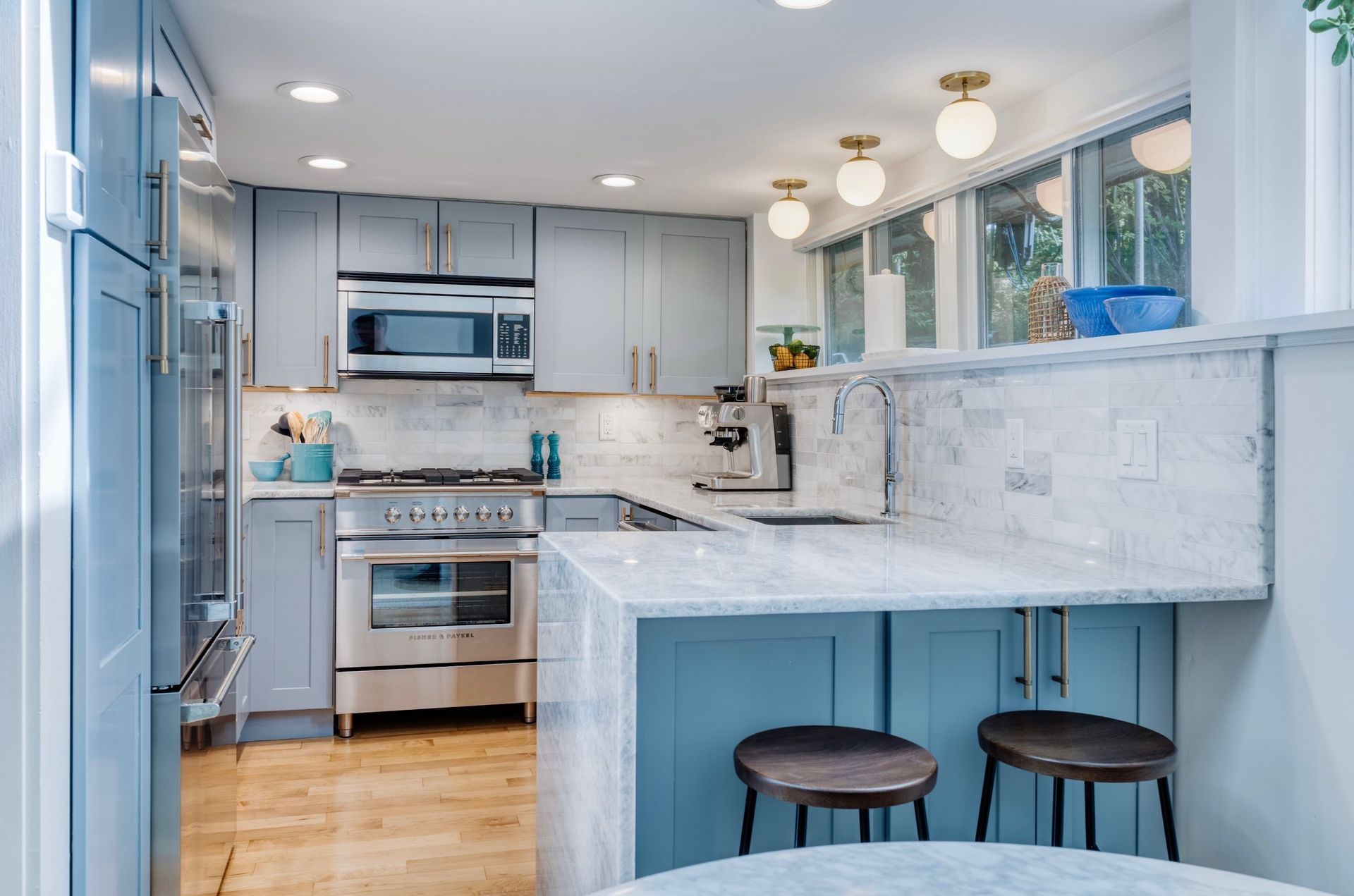 A kitchen with stainless steel appliances and blue cabinets