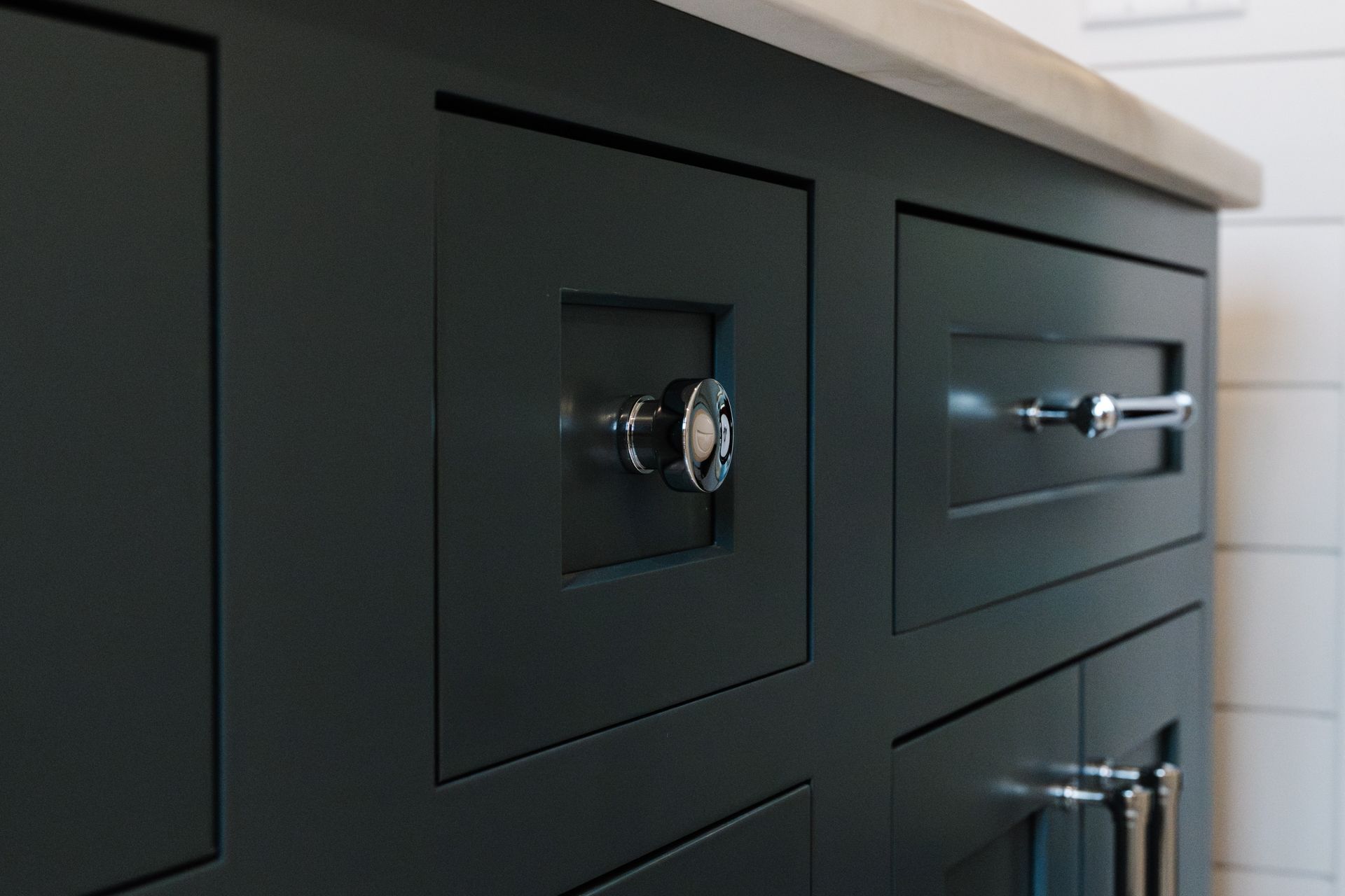 A bathroom vanity with black cabinets and chrome handles.