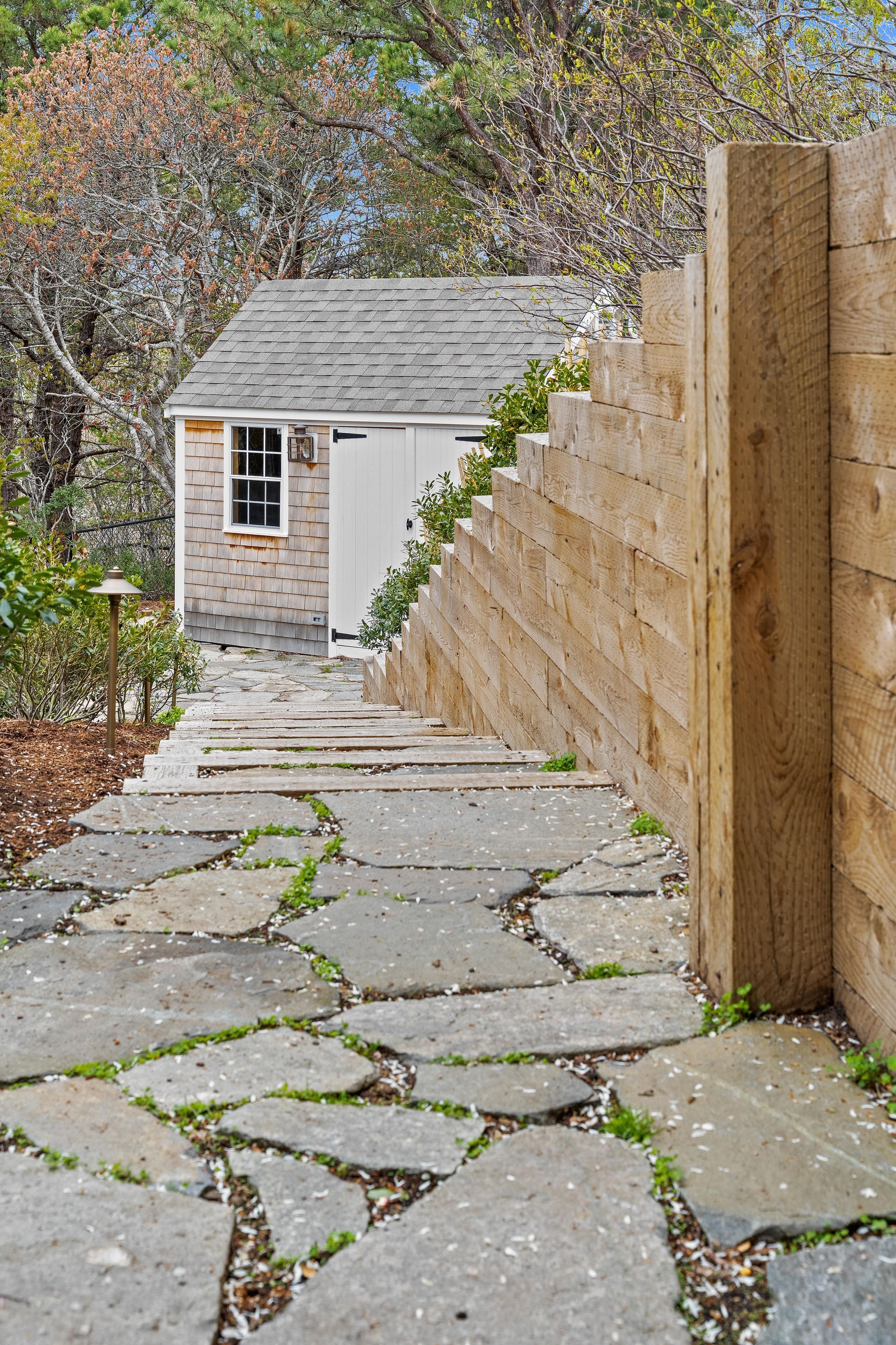 There is a stone path leading to a shed.