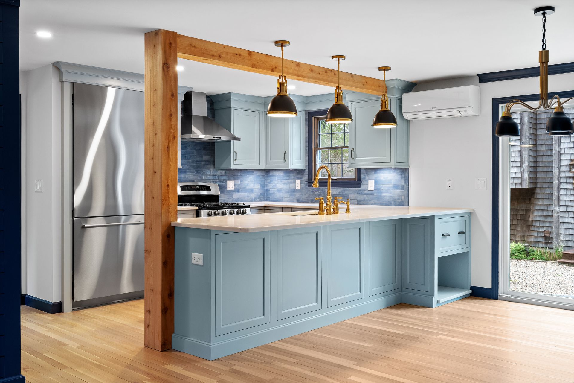 Kitchen with blue cabinets, stainless steel appliances, and a large island.