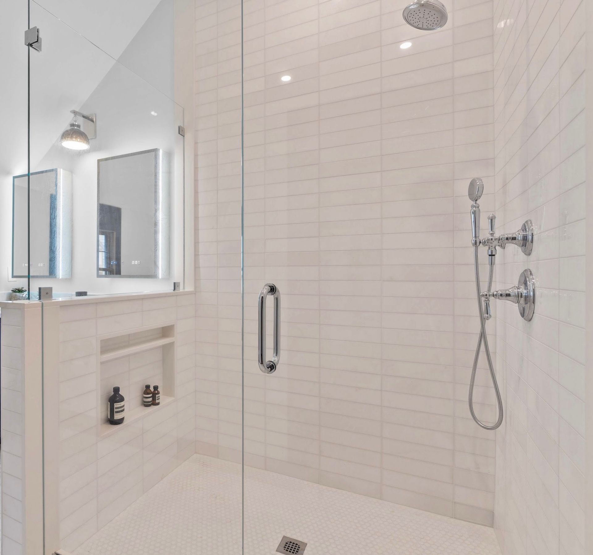 A bathroom with a walk in shower with a glass door