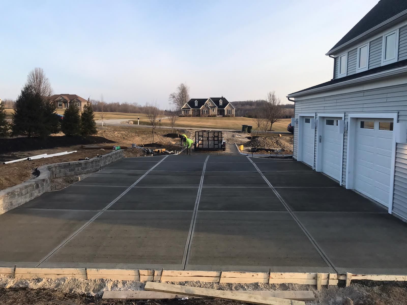 A concrete driveway is being built in front of a house.