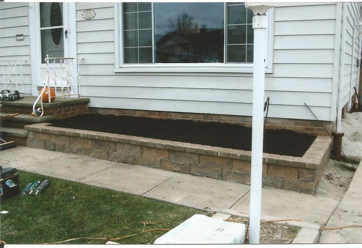 A white house with a planter in front of it