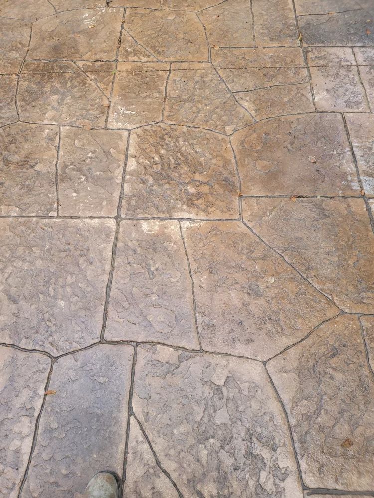 A close up of a stone floor with a person standing on it.